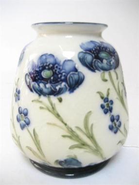 A MOORCROFT POTTERY FLORIAN WARE VASE of squat form, tube lined with poppies and forget-me-nots in blue on a cream ground, br