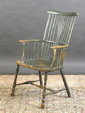 A comb back Windsor chair, early 19th Century, with a green paint finish, the wide elm seat on turned supports