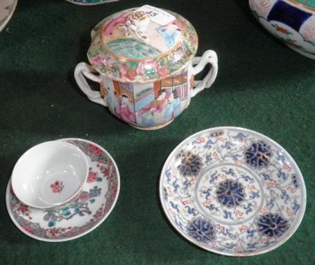 A Famille Rose lidded twin handled cup, a tea bowl and saucer and a saucer dish decorated with bold blue flowers on a busy fl