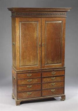 A George III Mahogany Cabinet, having a moulded cornice and  blind-fretted key-pattern frieze with. drawer, over  two fielded