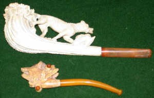 A meerschaum pipe, C19th, carved as a stag antler in full relief with a hunting dog retrieving a 