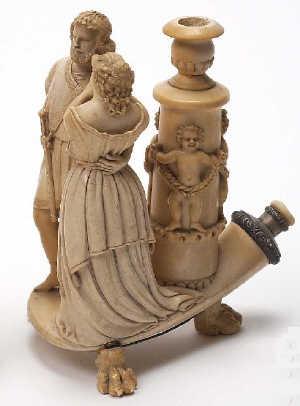An unusual meerschaum cigar holder on stand, C19th, with two Saxon figures, silver coloured metal