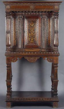 A Rare Late 16th Century Carved Oak Buffet Cupboard of slender proportions. The dentil moulded top having a  chequer-inlaid f