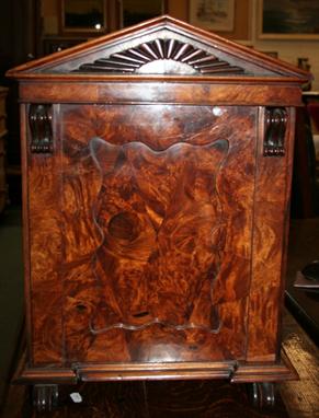 A Victorian walnut table cabinet, with architectural form, with panelled door and scrolled feet.