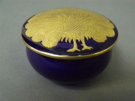A Royal Worcester blue ground pot and cover decorated with a gilt peacock, 2¾&quot; diameter