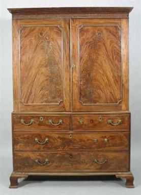 A 19th century mahogany linen press, the moulded dentil cornice to  a blind fret frieze, the panelled doors with  applied bor