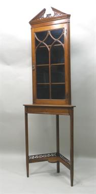 AN EDWARDIAN/EARLY 20TH CENTURY MAHOGANY CABINET ON STAND, the upper section having an architectural pierced and fretted pedi