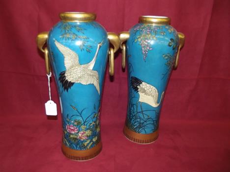 A pair of continental porcelain baluster vases, in the Minton style, decorated with cranes and prunus on a blue ground, heigh
