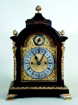 A walnut cased and gilt metal mounted mantel clock, late 19th/early 20th century, with concave pa