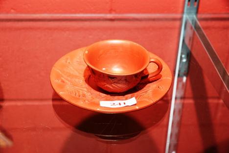 A 19th century Red Ware cup and saucer, moulded with ferns and insects 