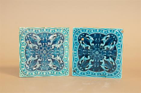 A pair of turquoise glazed Minton Collins and Co tiles, each decorated with mythical beasts, 11cm wide.