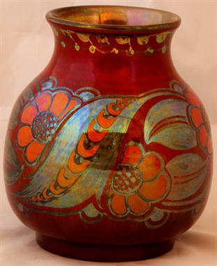 A Pilkingtons Royal Lancastrian lustre vase of bulbous form, decorated with stylised flowerheads and foliate on a ruby ground