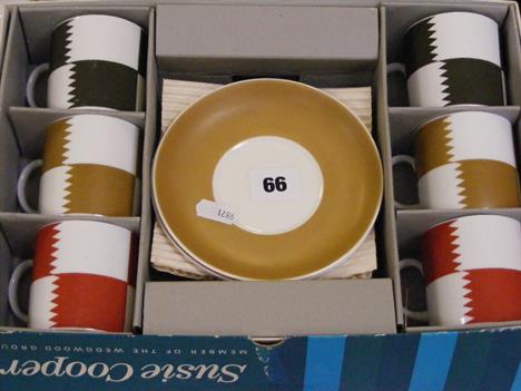 A boxed set of six Wedgwood Susie Cooper coffee cans and saucers in the three coloured 'Heraldry' pattern.