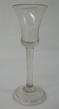 A George III late 18th century wine glass, the baluster bowl above a stright stem with tear drop inclusion, above a conical, 