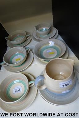 A collection of Susie Cooper Crown Works items including three two-handled dishes with saucers, plates, a cup & saucer, an ea