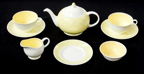 A Susie Cooper tea set for two, circa 1950, yellow polka dot design, including teapot, jug, bowl, plate, two cups and saucers
