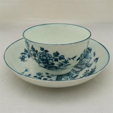 An English porcelain cup and saucer possibly Bow decorated in blue with three Oriental figures and flowers, circa 1770