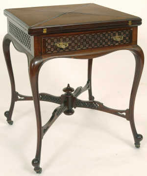 A Late Victorian Mahogany Envelope Card Table, with blind fret carved frieze having a drawer, on cabriole legs,  joined by a 